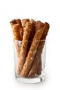 Crunchy salty pretzel rods in glass isolated on white.