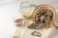 Crunchy snacks from linseed, oat flakes and various seeds in a basket, one with butter and parsley garnish, ingredients in glass Royalty Free Stock Photo