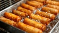 Crunchy vegetable spring rolls fried to golden perfection in a deep fryer, irresistibly delicious