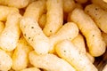 Crunchy yellow onion flavored crisps macro closeup. Simple treat, fresh corn cheese puffs, curls with flavoring quick snack food