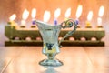 Cruse of oil made of silver, Hanukkah. with A stone menorah and candles background