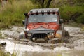 Crush Orange Jeep Rubicon crossing muddy pond Royalty Free Stock Photo