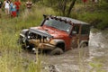 Crush Orange Jeep Rubicon crossing muddy pond Royalty Free Stock Photo