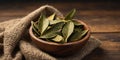 Crushed bay leaf in a wooden cup A whole bay leaf. Royalty Free Stock Photo