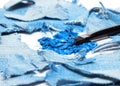 Crushed compact blue eyeshadow with rags of denim