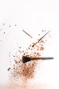 Crushed cosmetic powder with makeup brushes falling Royalty Free Stock Photo