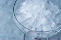 Crushed Ice in Cocktail Glass on Blue Surface. Royalty Free Stock Photo