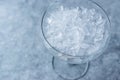 Crushed Ice in Cocktail Glass on Blue Surface. Royalty Free Stock Photo