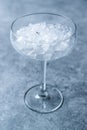 Crushed Ice in Cocktail Glass on Blue Surface. Royalty Free Stock Photo