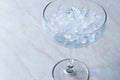 Crushed Ice in Cocktail Glass on Blue Surface. Royalty Free Stock Photo