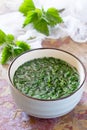 The crushed leaves brewed raw nettles on the kitchen table a rustic background Royalty Free Stock Photo