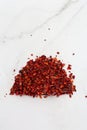 Crushed pimienta roja red pepper pile from top on white background. Heap of red pepper flakes, ground red chili pepper paprika Royalty Free Stock Photo