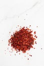 Crushed pimienta roja red pepper pile from top on white background. Heap of red pepper flakes, ground red chili pepper paprika Royalty Free Stock Photo