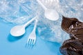 Crushed plastic spoons, forks, bottles and cups as a disposable waste on bright blue background. Environmental pollution Royalty Free Stock Photo