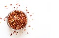 Crushed red chili pepper in glass bowl.  Top View on white background Royalty Free Stock Photo