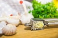 Crushing garlic to add to the dish. Whole and chopped garlic on a cutting Board made from natural oak. Fresh parsley. Royalty Free Stock Photo