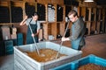 Crushing grapes for wine manufacturing in a cellar, winery and distillery. Industry employees, vintners and workers with Royalty Free Stock Photo