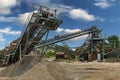 Crushing machinery, cone type rock crusher, conveying crushed granite gravel stone in a quarry open pit mining. Minning industry Royalty Free Stock Photo