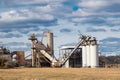 Crushing machinery, cone type rock crusher, conveying crushed granite gravel stone in a quarry open pit mining processing plant Royalty Free Stock Photo