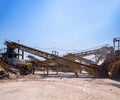Crushing machinery, cone type stone crusher, conveying crushed granite gravel stone in a quarry open pit mining. Processing plant Royalty Free Stock Photo
