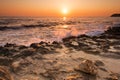 Crushing waves on jagged rocks during sunrise Royalty Free Stock Photo