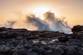 Crushing waves on the rocks with sun in the background