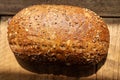 Crusty homemade organic wholegrain bread on a rustic wooden table.