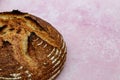 A high angle view of a crusty loaf of bread against a pink background Royalty Free Stock Photo