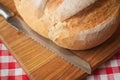 Crusty loaf at top view are on a wood table with knife