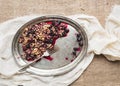 Crusty oat granola with fresg berries on a silver dish over a pi