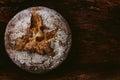 Crusty round loaf of healthy whole grain bread on dark wooden table background with white flour on top. top view of buckwheat Royalty Free Stock Photo