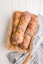 Crusty rustic baguette in basket on white table. Top view Royalty Free Stock Photo