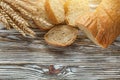 Crusty sliced bread rye ears on wooden surface Royalty Free Stock Photo