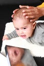 Crying baby boy with reflection in silver box Royalty Free Stock Photo