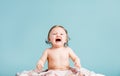 Crying baby girl sitting on a blanket Royalty Free Stock Photo