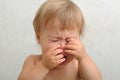 Crying baby rubbing her eyes Royalty Free Stock Photo