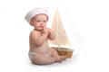 Crying Baby Sitting up Wearing Sailor Hat on White Background Royalty Free Stock Photo