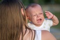 Crying baby who is being held by her mother