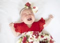 Crying caucasian baby girl in a red dress. Crying child. Royalty Free Stock Photo