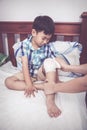 Crying child injured. Mother bandaging son`s knee. Vintage tone Royalty Free Stock Photo