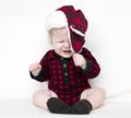 Crying Christmas baby trying to pull off hat