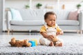 Crying Cute African American Infant Boy Sitting On Floor In Living Room Royalty Free Stock Photo