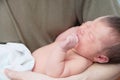 Crying infant baby, adult holding newborn