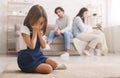 Crying little girl sitting separately from parents after their arguing Royalty Free Stock Photo