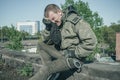 Crying military man and wiping his tears on a black balaclava