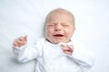 Crying newborn baby on changing table. Cute little girl or boy two weeks old. Dry and healthy body and skin concept Royalty Free Stock Photo