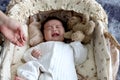 Crying newborn infant baby boy lying down on beautiful crib basket on bed, little child sleeping, mother hand gentle touching him Royalty Free Stock Photo