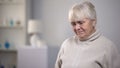 Crying old lady sitting alone in rehabilitation center, suffering from illness