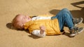 Crying and screaming baby boy lying on the ground on street. Upset children, negative emotions, kids problems Royalty Free Stock Photo