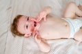Crying screaming toddler baby boy is lying on the bed. Unhappy child c Royalty Free Stock Photo
